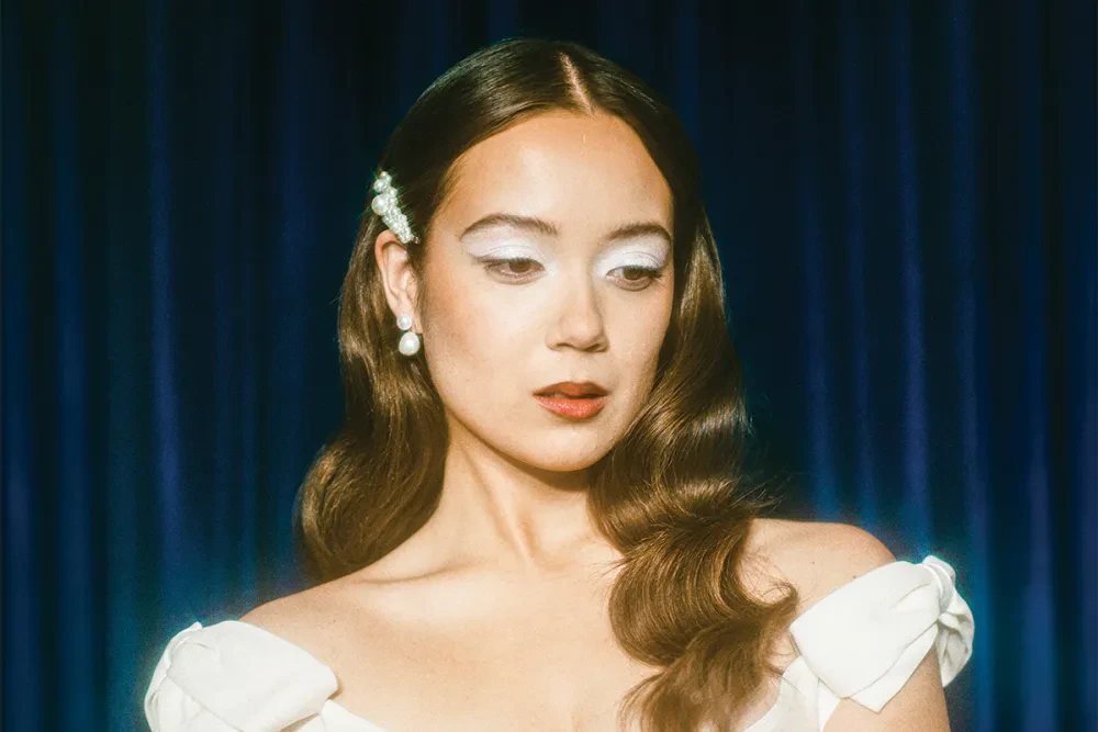 Editorial gallery of Laufey styled in deep winter looks featuring sapphire, garnet, and chrome accents, highlighting midnight navy, crimson, amethyst, gunmetal, and snow white.