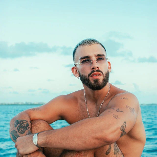 Manuel Turizo wearing muted autumn ensembles with velvety textures and gentle warmth, showcasing desert rose, sage green, oatmeal, copper brown, and soft teal from the Soft Autumn palette.