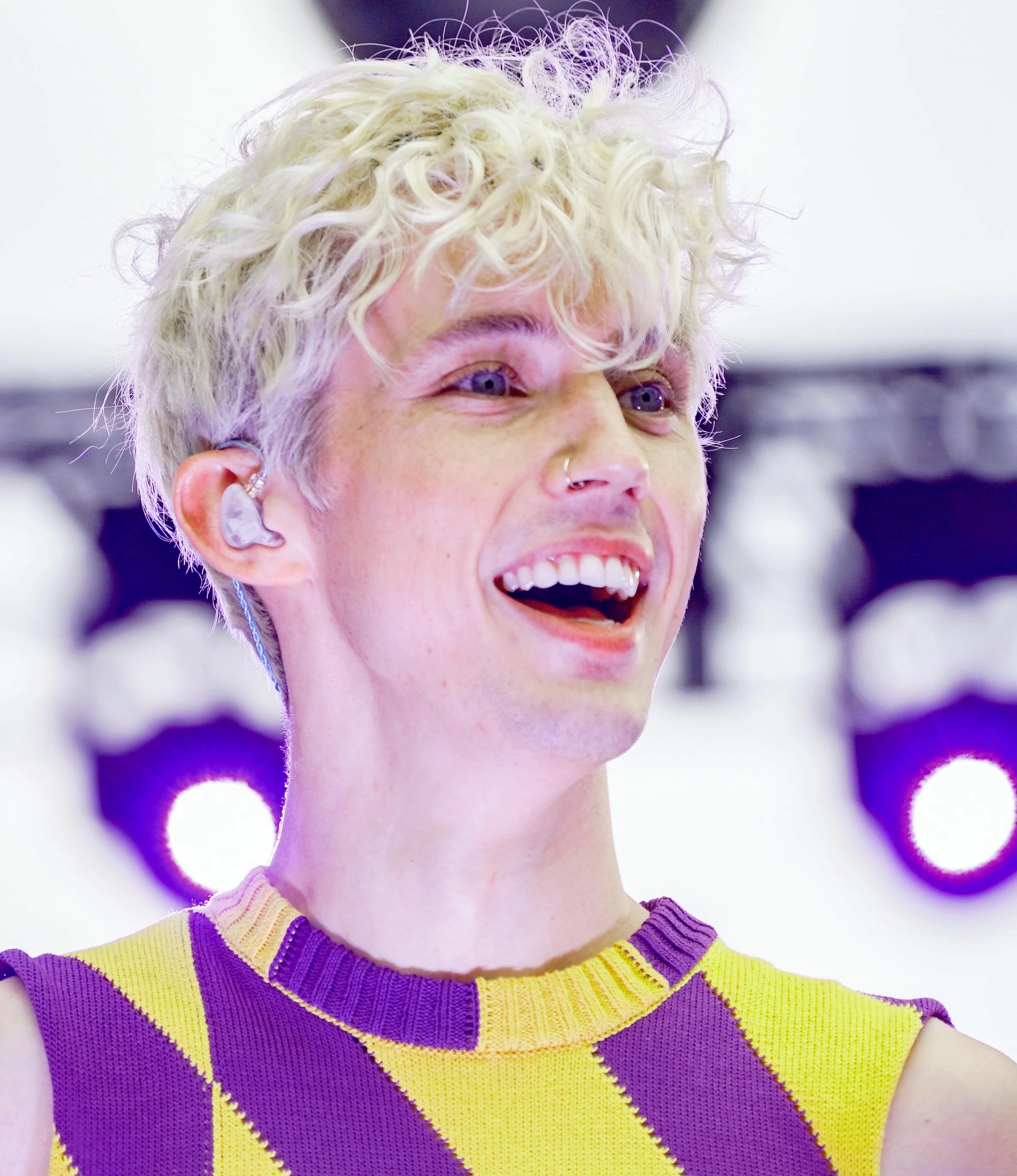 Editorial gallery of Troye Sivan styled in bold winter ensembles mixing neon pops, inky black, and chrome sparkle, highlighting ultra violet, neon fuchsia, electric jade, polished pewter, and onyx.